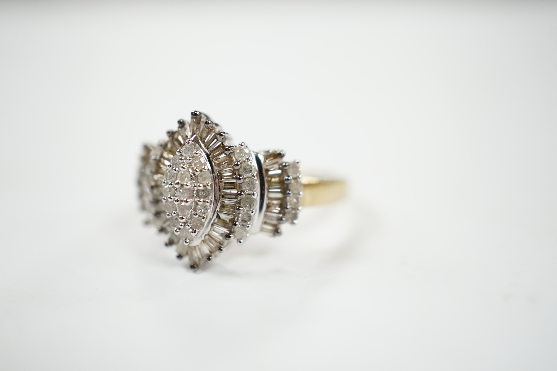 A modern 9ct gold and diamond navette shaped cluster dress ring, set with baguette and round cut stones and diamond cluster set shoulders, size O/P, gross weight 3.2 grams.